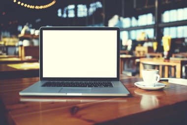 Açık dizüstü bilgisayar ve kahve Cafe bar iç ahşap bir masa üzerinde yalan