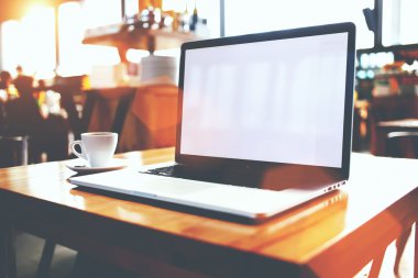 Açık dizüstü bilgisayar ve kahve Cafe bar iç ahşap bir masa üzerinde yalan