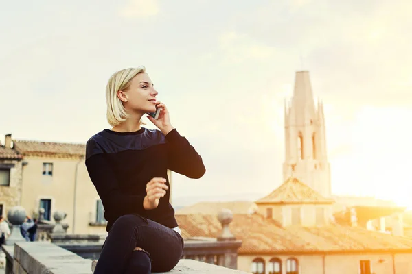 Urocza dziewczyna Hipster dzwoni przez telefon komórkowy, a odpoczywa po wycieczce na starym mieście — Zdjęcie stockowe