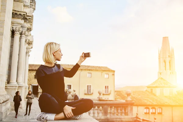 ゴージャスな女性観光客は、彼女の携帯電話に美しい都市の風景のビデオを撮影しています — ストック写真
