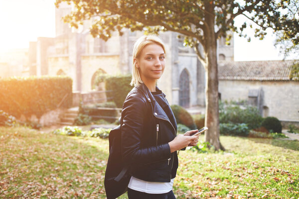 Young woman wanderer is using mobile phone for navigation during walking tour