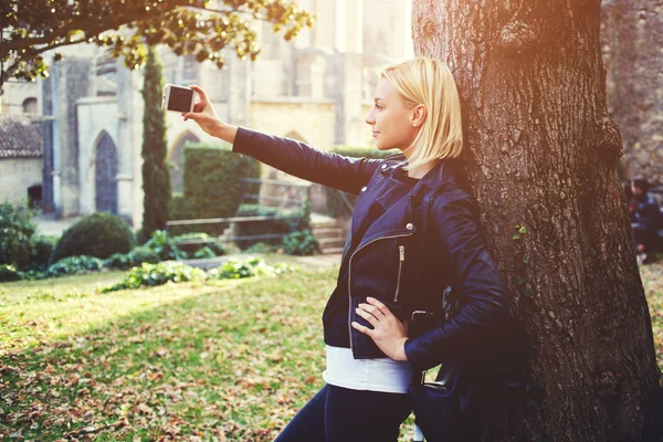 Attractive woman traveler is photographing herself on cell telephone during her walking — Stock Photo, Image