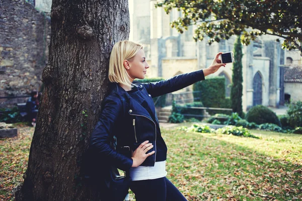 Woman with cool style is posing, while is making self portrait on cell telephone — Stock Photo, Image