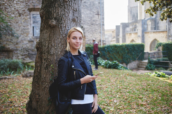 Beautiful woman wanderer is using cell telephone for navigation during her walk tour