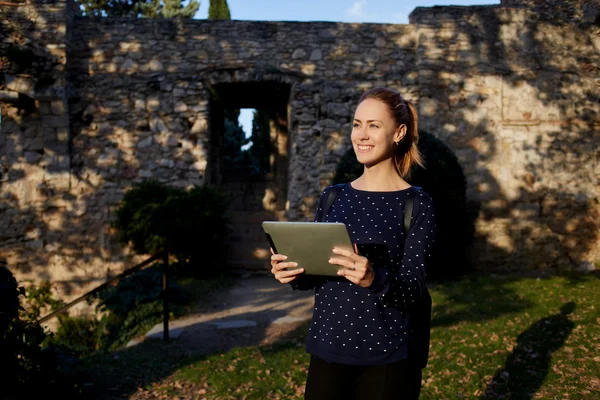 Žena s digitálním tabletu v rukou se usmívá při rekreaci jarní den — Stock fotografie