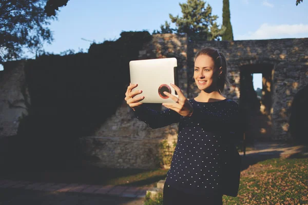 Smiling happy female student is photographing herself with front digital tablet camera — Stock Photo, Image