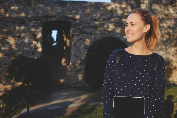 Sonriente chica hipster con tableta digital está disfrutando de la noche soleada al aire libre — Foto de Stock