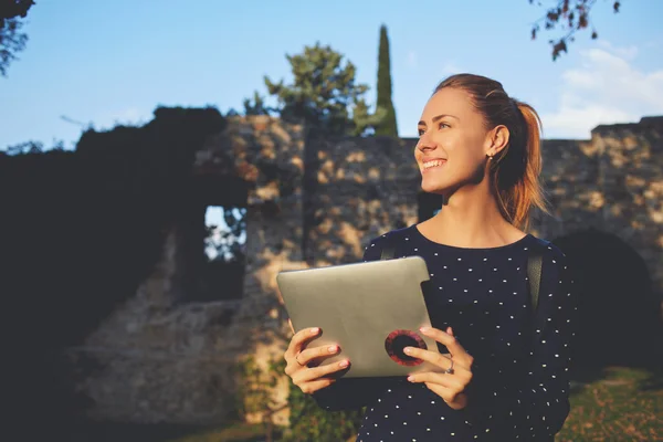 Gelukkig hipster meisje met digitale tablet in handen is op zoek naar iemand tijdens pauze Universiteit — Stockfoto