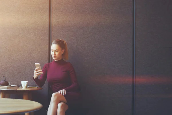 Säker affärskvinna med hennes smarta telefonen medan du kopplar av efter arbetsdagen i kafé — Stockfoto