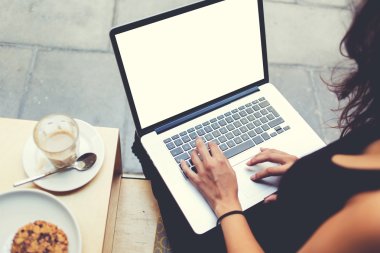 İş kadınının geri görünümü kafede iş molası sırasında dizüstü bilgisayar klavyesinde metin yazıyor. 