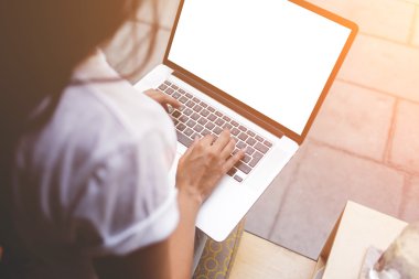 Young student girl is connecting to sidewalk cafe wireless via laptop computer