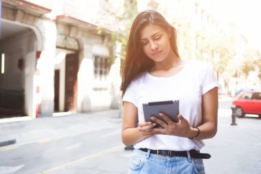 Şık bir hipster kız Portresi kentsel ortamda navigasyon için dijital tablet kullanıyor