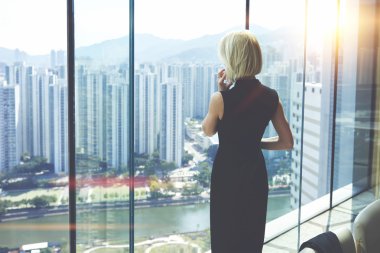 Young businesswoman is talking on mobile phone during work break