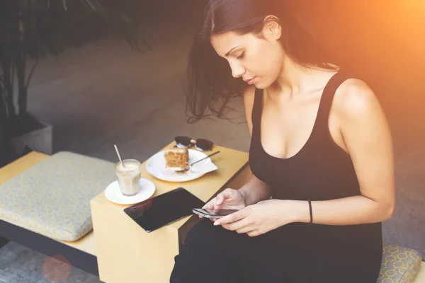Mulher está procurando informações em rede usando telefone celular durante almoço no intervalo de trabalho — Fotografia de Stock