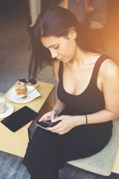 Atractiva latina escribiendo mensajes de texto mientras está chateando en red por teléfono móvil . —  Fotos de Stock