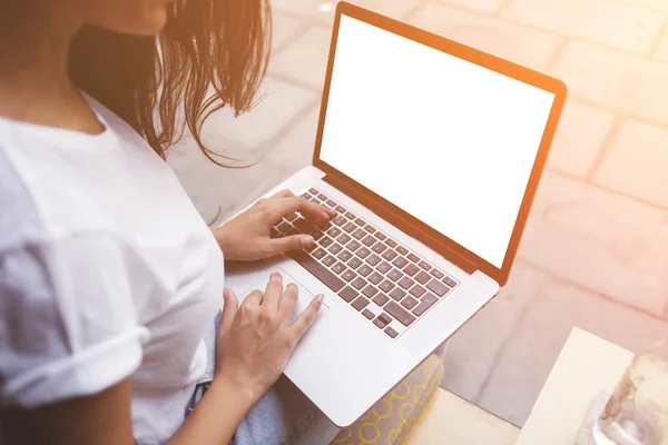 Back view of female student is typing text on laptop keyboard during class break in cafe. — Stock Photo, Image