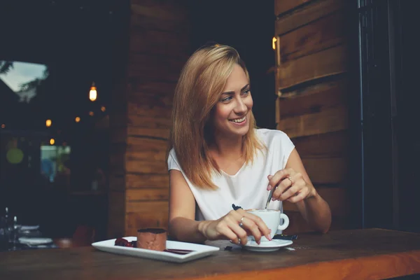 Femeia tânără cu zâmbet frumos privind departe în timp ce stătea în cafenea în timpul pauzei de cafea — Fotografie, imagine de stoc