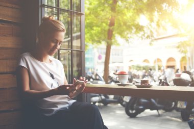 Rahat kafede otururken cep telefonumetinden kısa mesaj okuyan çekici kadın 