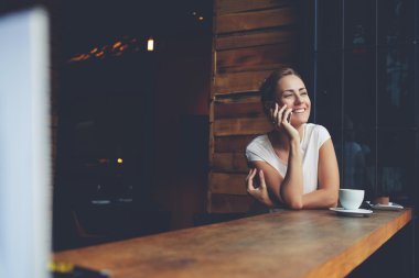 Yaz günü yürüdükten sonra dinlenirken cep telefonu ile arayan gülümseyen hipster kız 