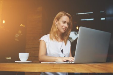 Başarılı kadın serbest kafede sabah kahvaltısı sırasında mesafeli çalışma için net kitap kullanarak 