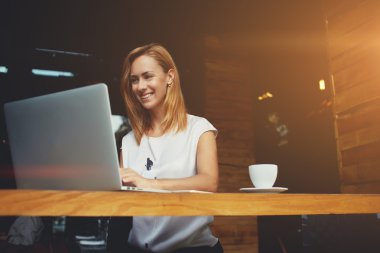 Cafe bar kahve molası sırasında dizüstü bilgisayar üzerinde çalışan güzel mutlu kadın