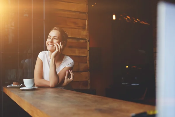 Sonriente chica hipster llamando con teléfono celular mientras se relaja después de caminar en el día de verano — Foto de Stock