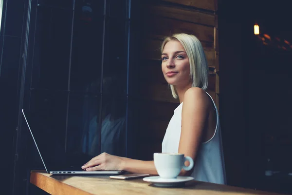Accogliente attraente freelance femminile che utilizza il net-book portatile per il lavoro a distanza — Foto Stock