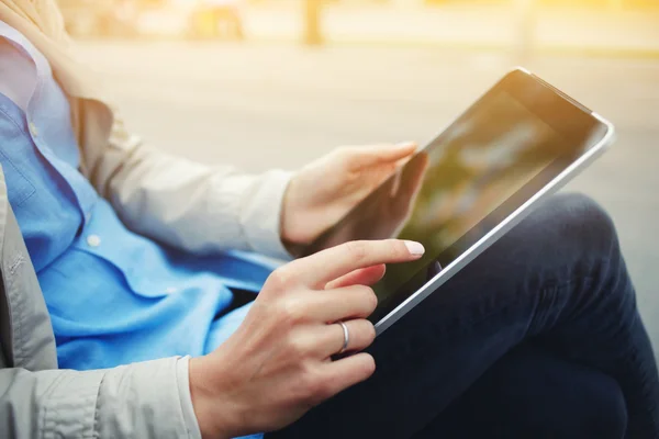 Closely of hipster girl is using touch screen digital tablet while sitting in the park outdoors — Stock Photo, Image