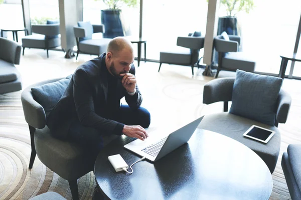 Homem de negócios lendo em rede via computador portátil — Fotografia de Stock