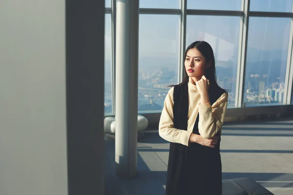 Businesswoman looking in skyscraper window — Zdjęcie stockowe