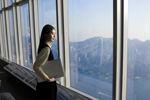 Asian skilled businesswoman holding laptop