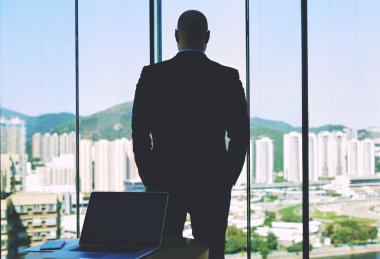 Man confident entrepreneur looking in window 