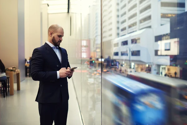 Mladý muž, psaní na mobilních telefonů — Stock fotografie