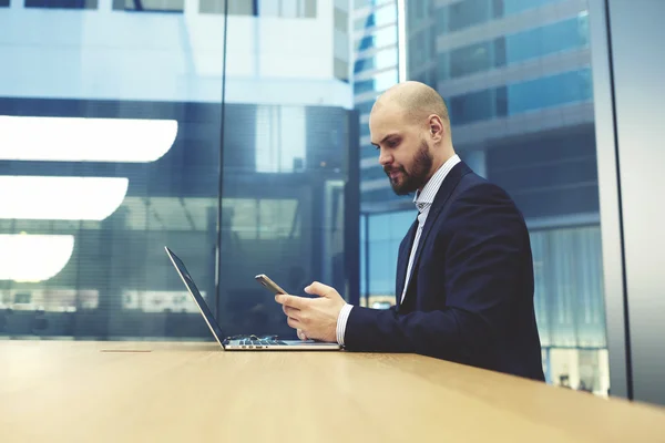 Intelligent businessman reading text message — Stockfoto