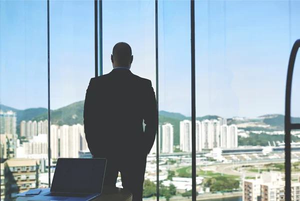 Young man entrepreneur looking in window — ストック写真