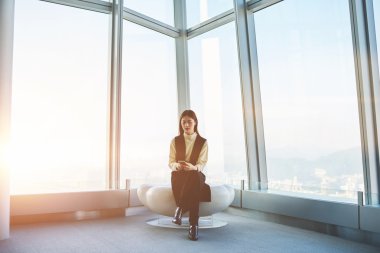  Yetenekli Asyalı kadın Yöneticisi e-posta kontrol etmek için cep telefonu kullanıyor