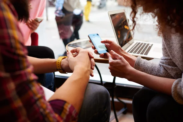 Nära bild av kvinna gör en on-line köp via cell telefon, tag sitter med vänner i hipster café inredning. — Stockfoto