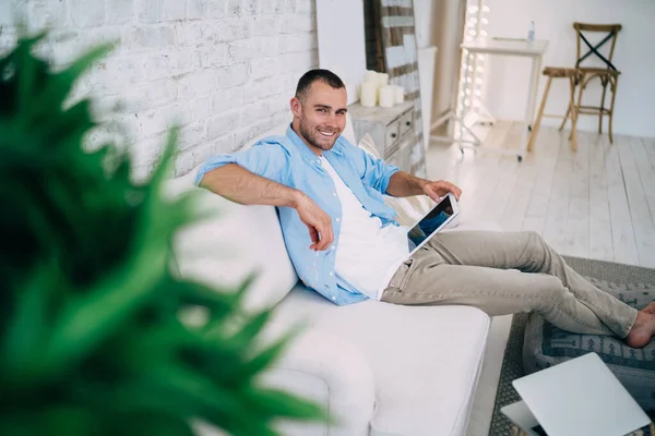 Cheerful Male Sitting Comfortable Sofa Crossed Legs Using Tablet While — Stock Photo, Image