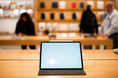 Stylus, klavye ve boş ekran ile modern mağazadaki ahşap masanın üzerine yerleştirilmiş tablet bilgisayarın yukarısından