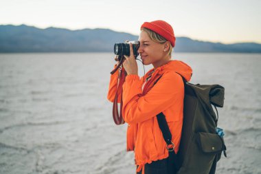 Rahat giysiler içinde, haftasonunun keyfini çıkarırken inanılmaz manzaranın fotoğrafını çeken içerikli bir kadın.