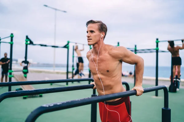 Caucasian Strong Athlete Doing Exercises Outdoors Bars Listening Music Electronic — Stock Photo, Image