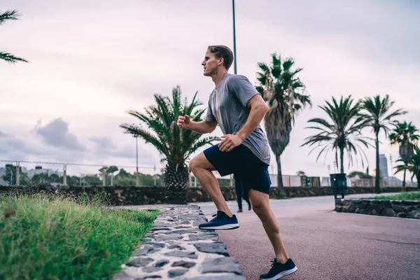 认真参加户外运动的男性运动员在开始街头锻炼前 先确定了他们在户外运动时的腿 肌肉强度和有氧运动达到健身目标的能力 — 图库照片