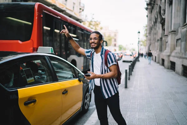 Smiling Dark Skinned Male Traveler Raising Hand Stopping Cars Transport — Stock Photo, Image