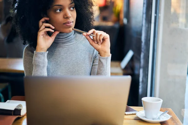 Unga Tankeväckande Afroamerikanska Kvinnliga Frilansare Ringa Samtal Smartphone Och Titta — Stockfoto