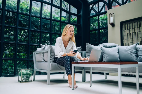 Empresária Concentrada Mensagens Roupa Elegante Laptop Smartphone Navegação Enquanto Senta — Fotografia de Stock