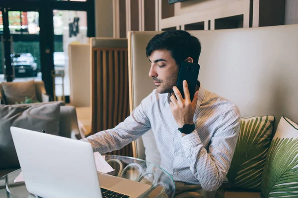 Poważny Skoncentrowany Przedsiębiorca Latynoski Robi Notatki Mając Telefonii Komórkowej Doradztwo — Zdjęcie stockowe