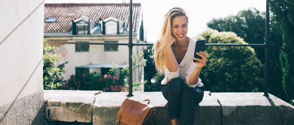 Glimlachend Casual Blond Met Smartphone Lederen Rugzak Buurt Van Kijken — Stockfoto