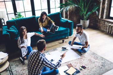 Lotus 'ta oturan mutlu, etnik çeşitliliğe sahip meslektaşlarımızdan gülümseyerek ve birbirlerine bakarak başlangıç konularını tartışıyoruz.