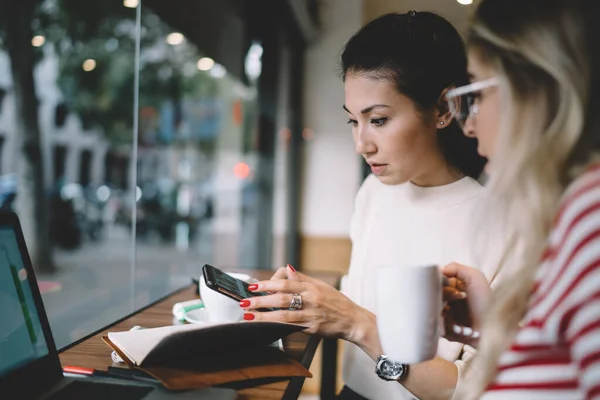 Asian Female Showing Information Mobile Phone Caucasian Female Colleague Working — Stock Photo, Image