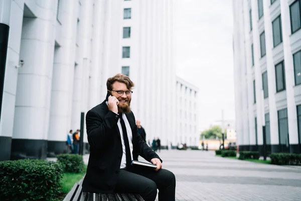 Happy Bearded Entrepreneur Glasses Elegant Formal Clothes Sitting Bench Talking — Stock Photo, Image